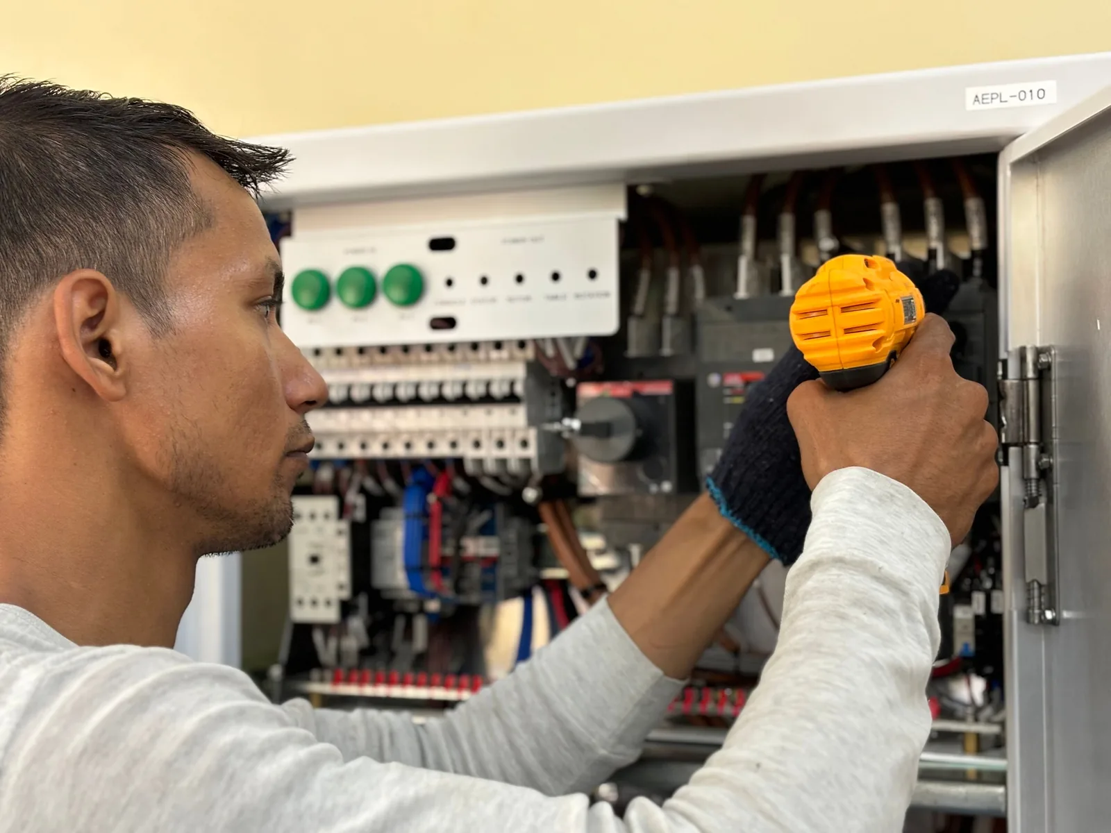 An electrician working on a commercial control panel, for subpanel installation in Surrey