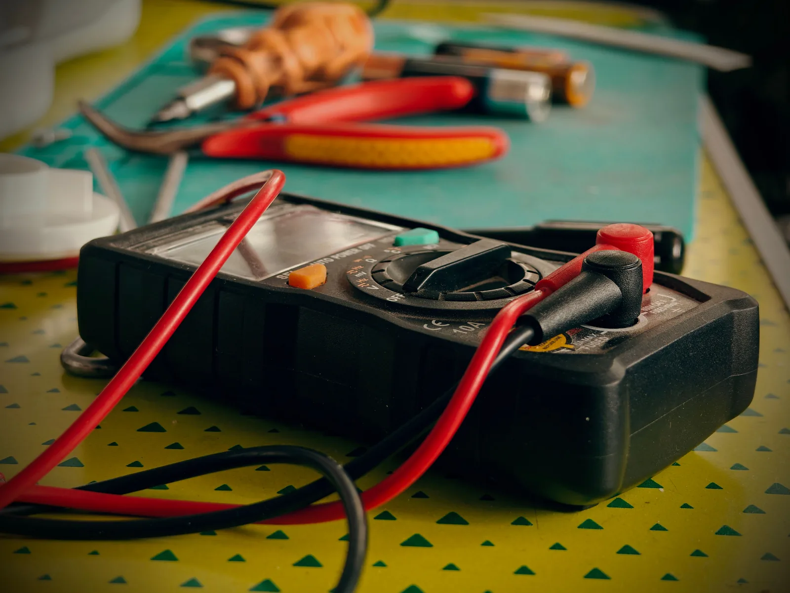 A multimeter and hand tools ready for a diagnostic visit, for electrician in Surrey